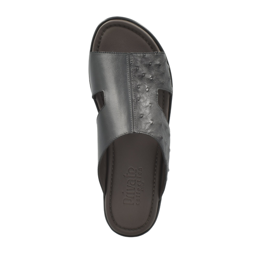 Black ostrich skin slide sandals from Private Collection with textured upper and open toe design