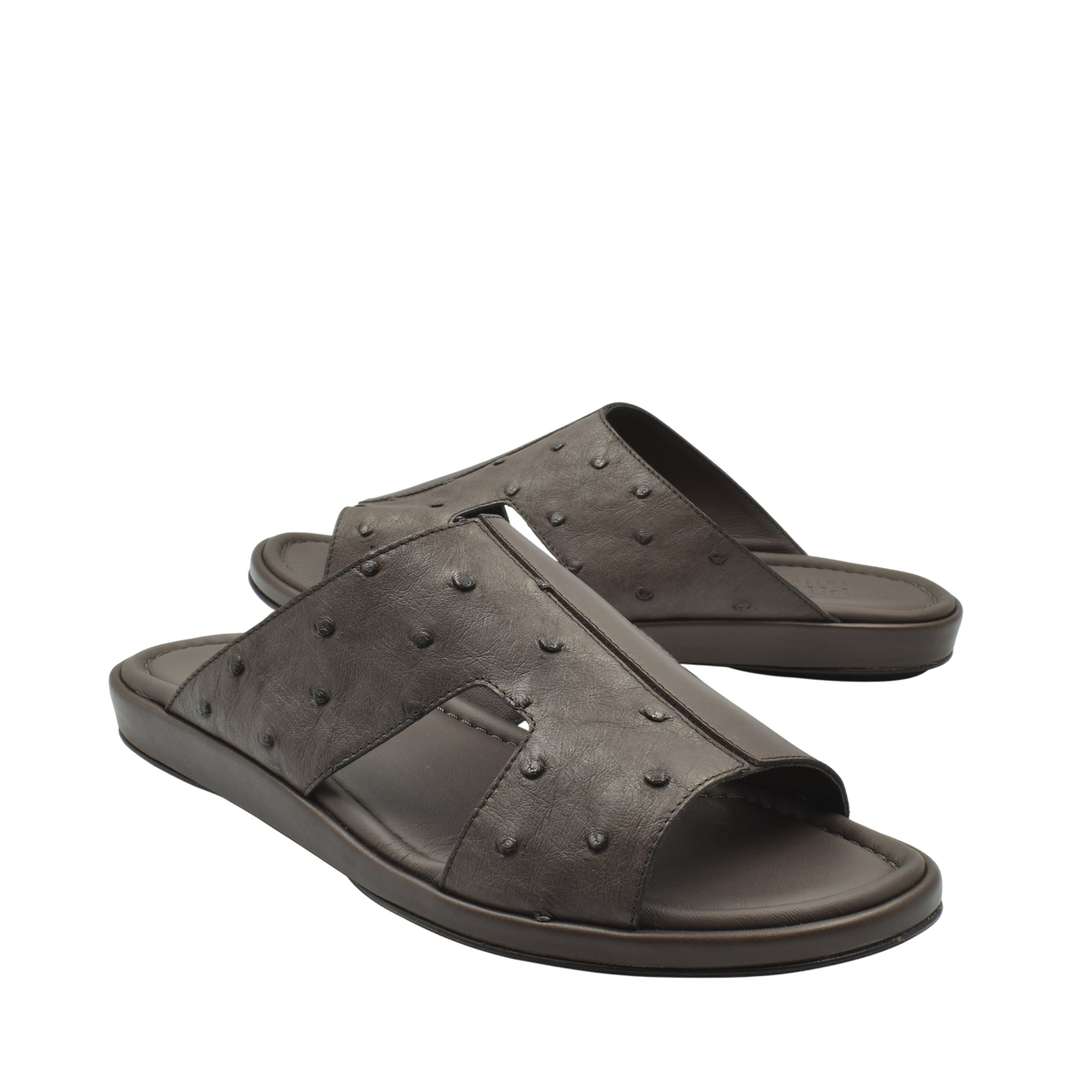 Pair of brown ostrich skin slide sandals with textured upper and cushioned sole