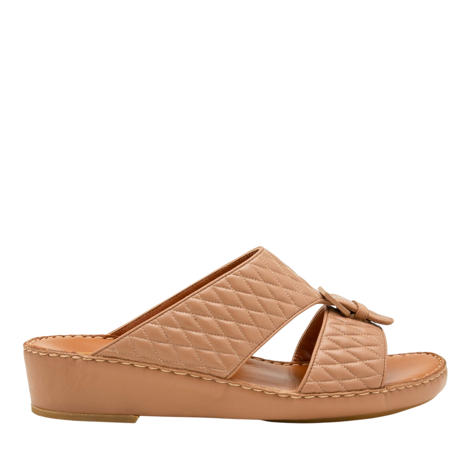 Tan quilted luxury slip-on footwear with low wedge heel and bow detail for stylish comfort