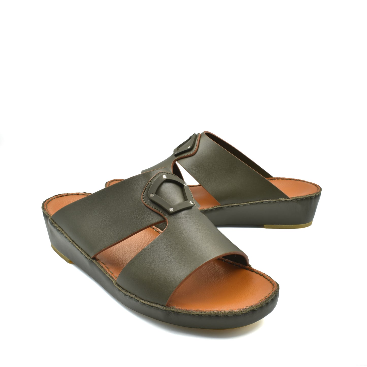 Pair of green natural leather slide shoes with buckle detail and cushioned sole for comfort