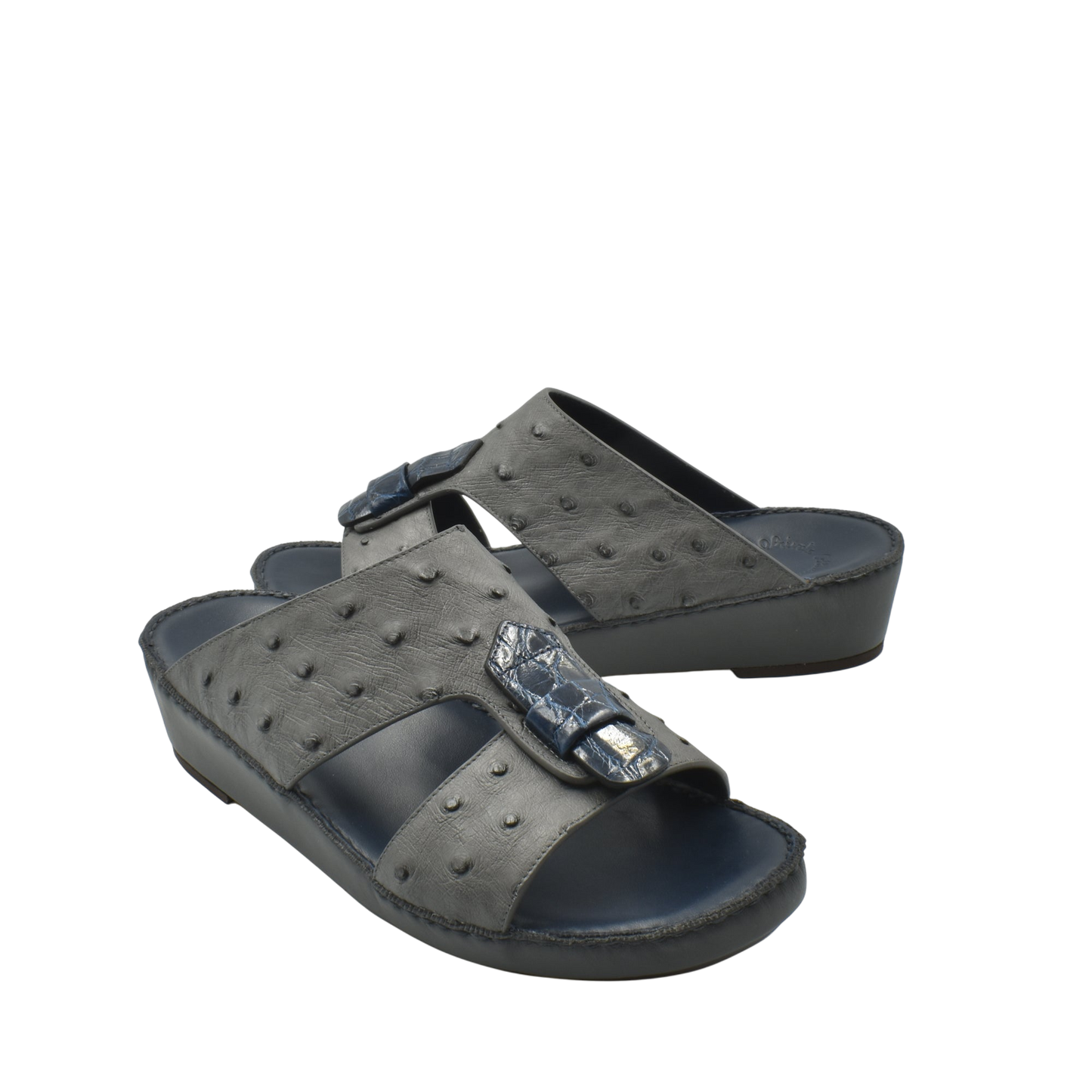 Black ostrich leather sandals with raised texture and decorative buckle on thick sole