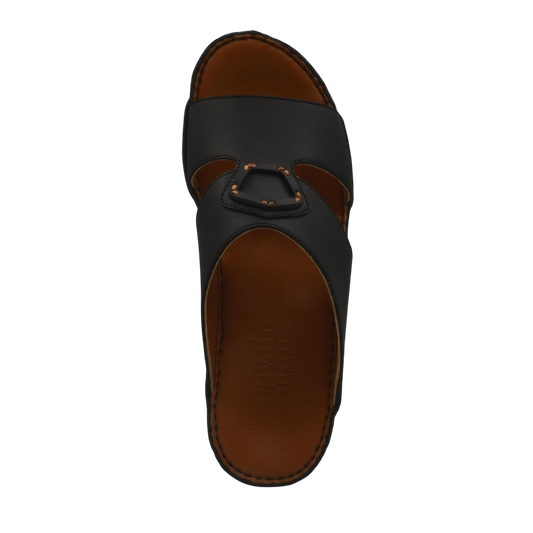 Comfortable leather slip-on sandals in black with brown cushioned sole and open toe design