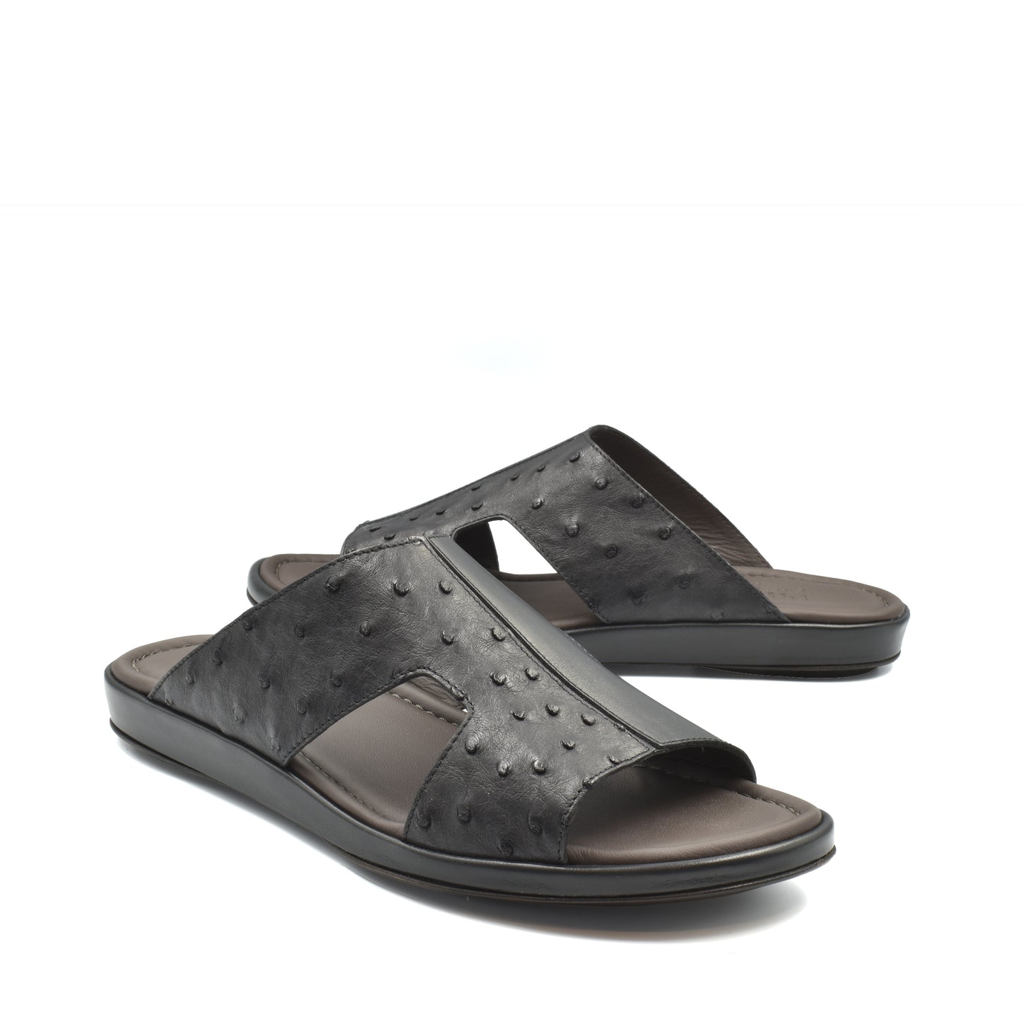 Black ostrich skin slide sandals with textured leather upper and comfortable cushioned sole