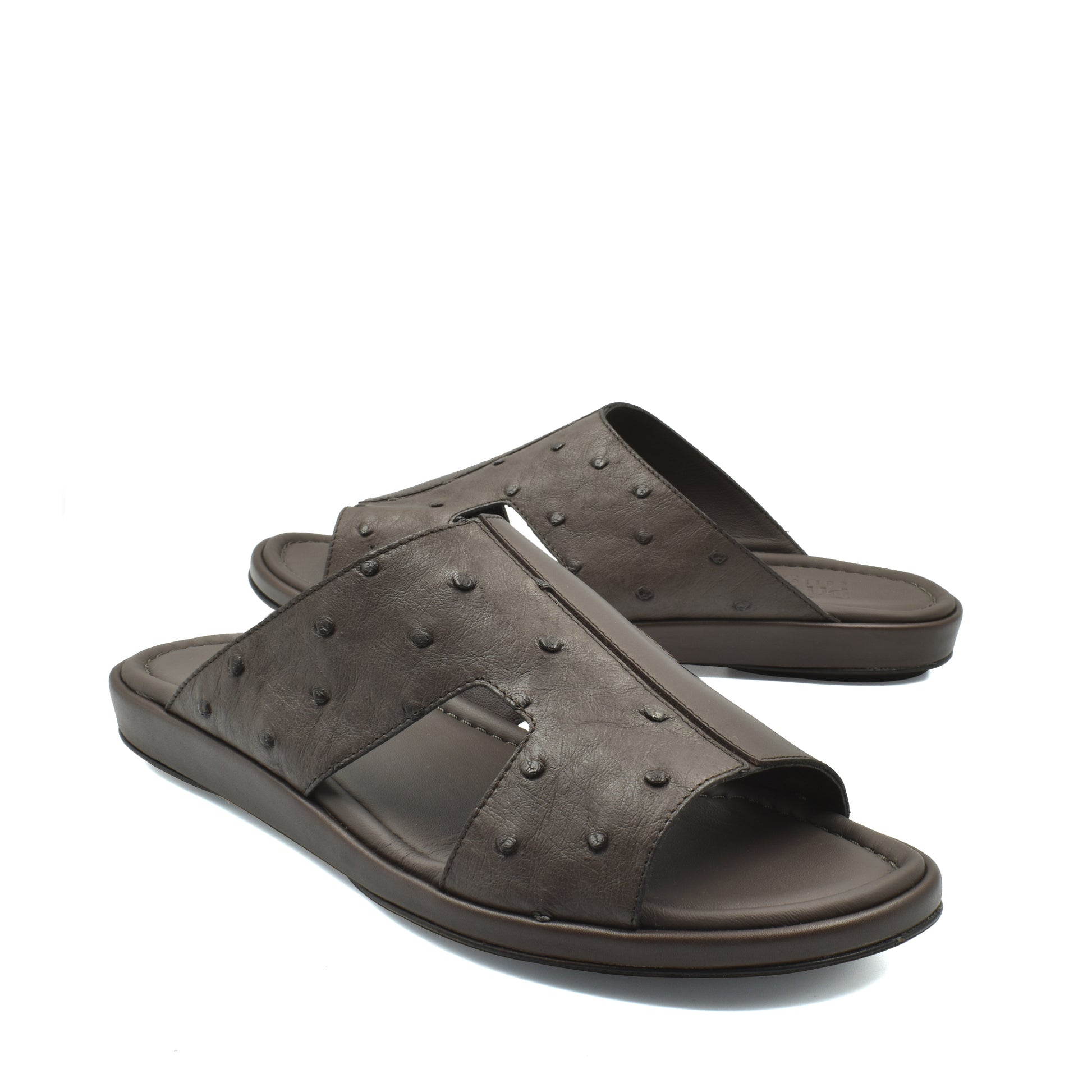 Pair of brown ostrich skin slide sandals with textured upper and cushioned sole
