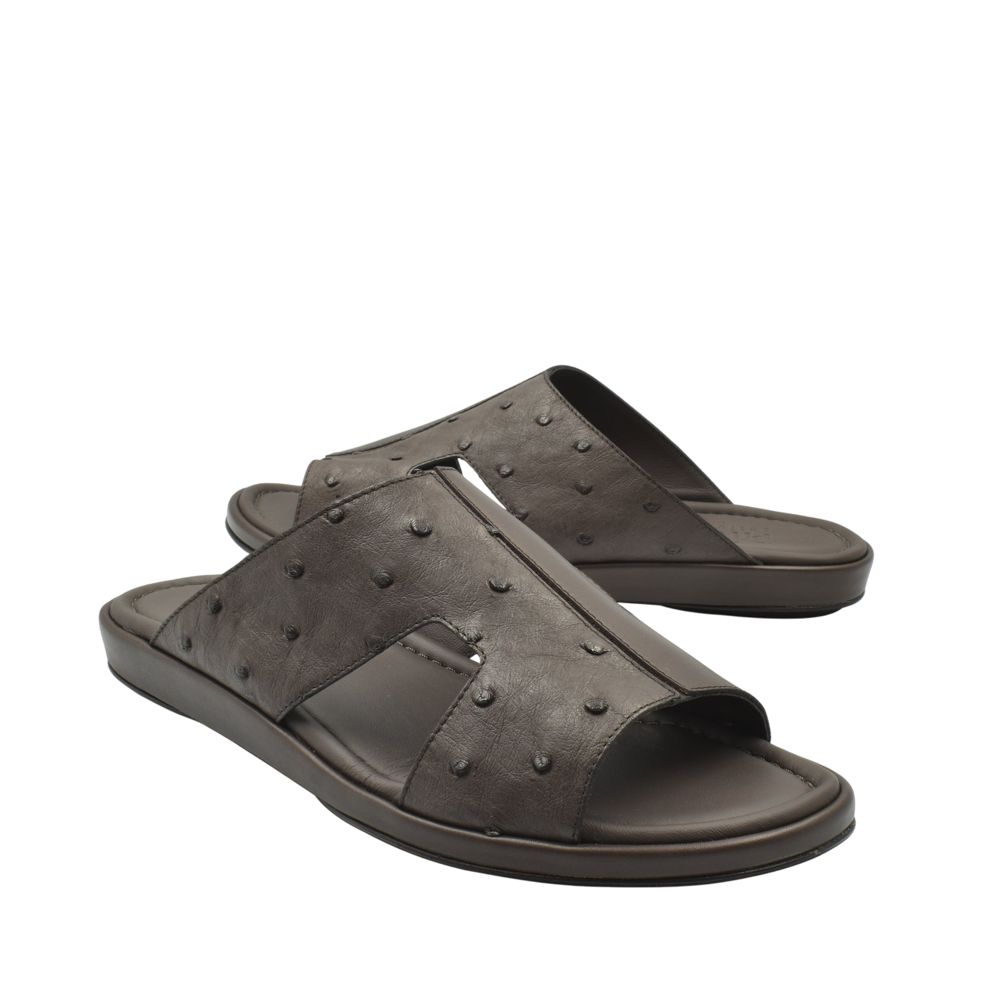 Pair of brown ostrich skin slide sandals with textured upper and cushioned sole