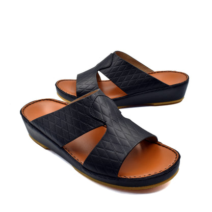 Black handcrafted Italian sandals with quilted leather straps and cushioned tan footbed by Private Collection