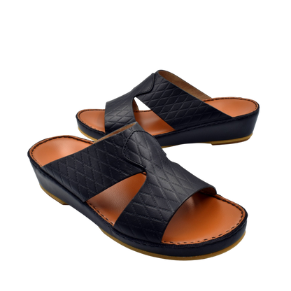 Black handcrafted Italian sandals with quilted leather straps and cushioned tan footbed by Private Collection