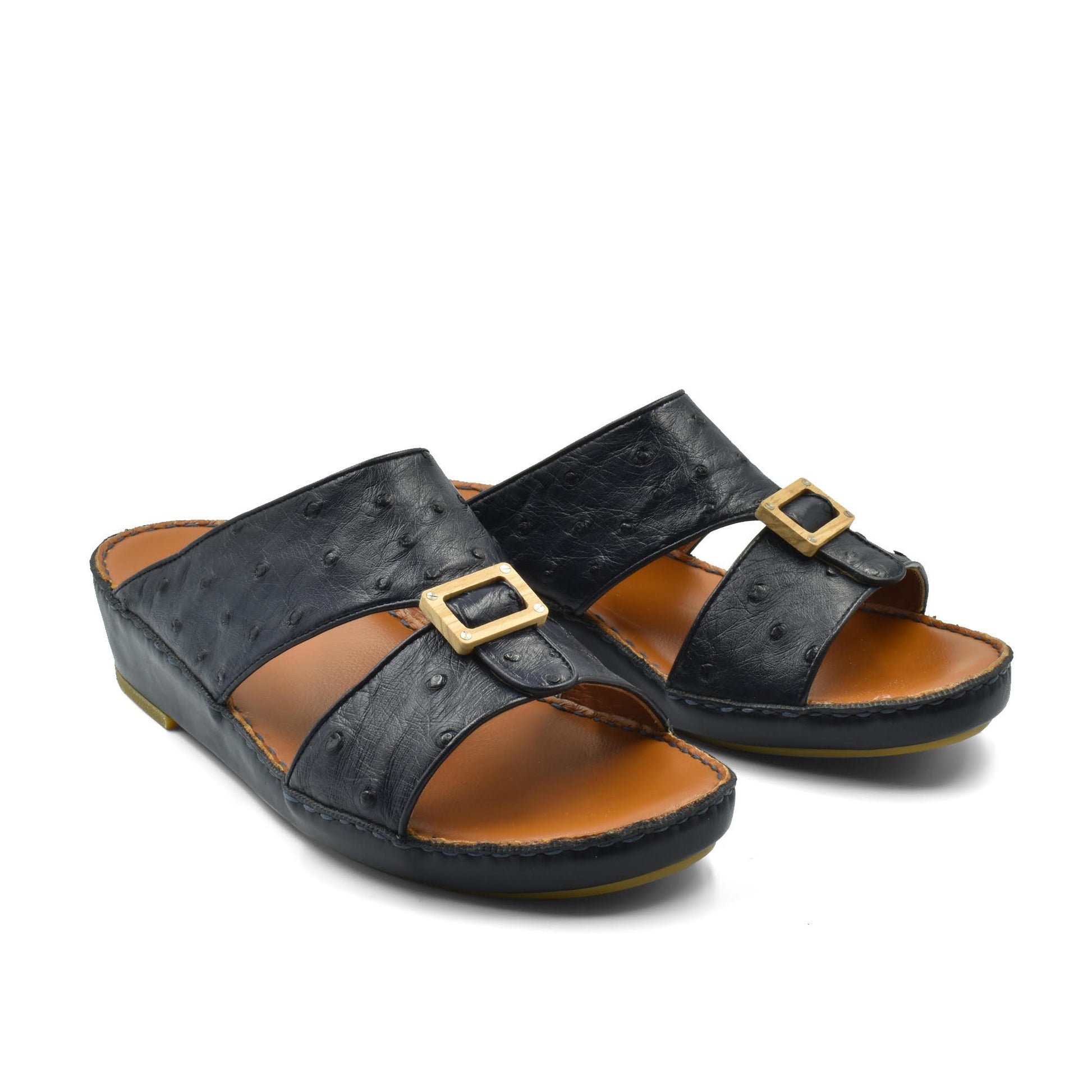 Black handcrafted olive sandals with gold buckle detail and comfortable brown footbed