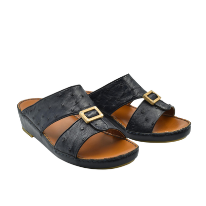 Black handcrafted olive sandals with gold buckle detail and comfortable brown footbed