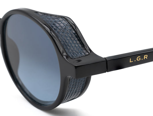 Close-up of black sunglasses with blue textured detailing from a luxury eyewear collection