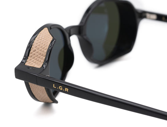 Close-up of black round frame luxury sunglasses with textured beige temple detailing and LGR logo