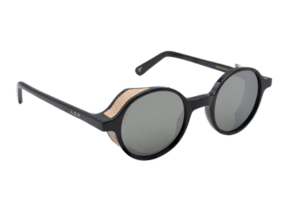 Black round frame luxury sunglasses with textured beige side shields and dark lenses