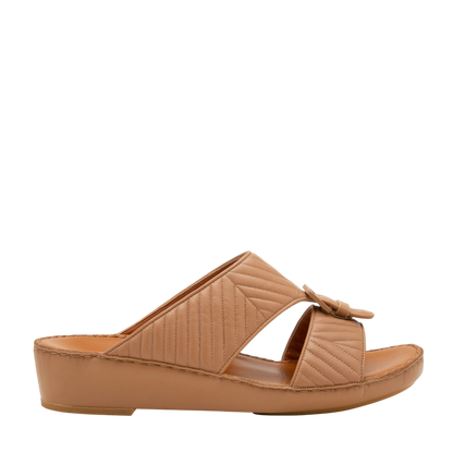 Tan wedge slide sandals featuring luxury matelasse footwear design with quilted straps and buckle detail