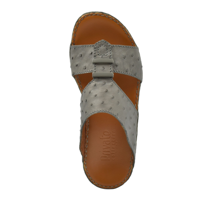 Top view of luxury ostrich sandals in gray with tan leather sole and detailed stitching