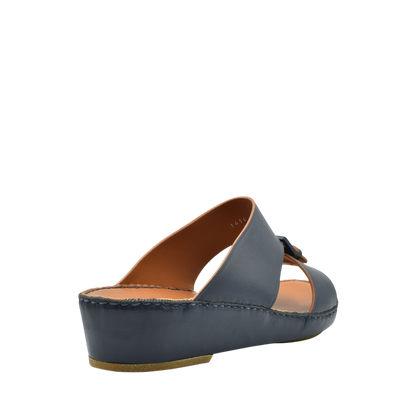 Side view of black natural contrast sandals with a low wedge heel and leather upper