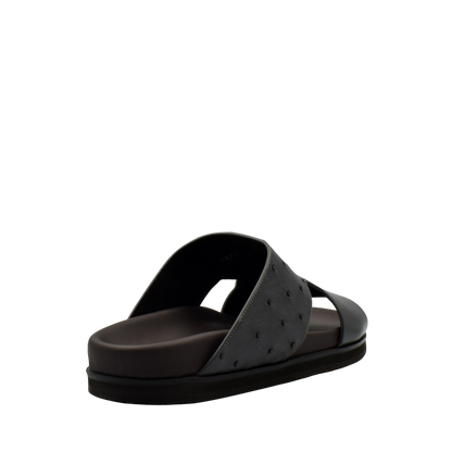 Black slide sandal from private collection featuring ostrich leather footwear design with textured upper