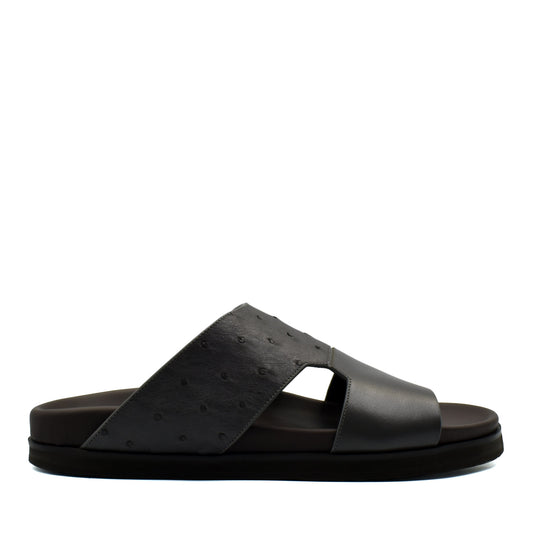 Black slide sandal featuring premium ostrich leather footwear with open toe and comfortable sole