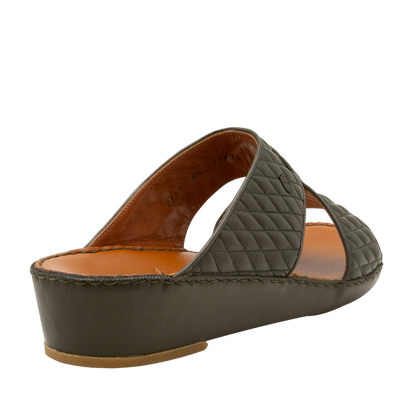 Side view of black Peninsula Lamb Matelasse sandals with quilted leather straps and cushioned sole