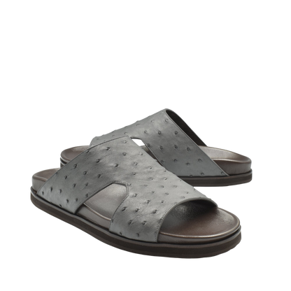 Gray slide sandals made from premium ostrich leather footwear with textured pattern and open toe design