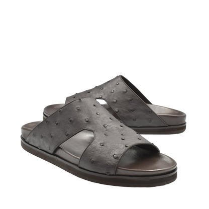 Pair of premium ostrich leather footwear black slide sandals with textured surface and open toe design