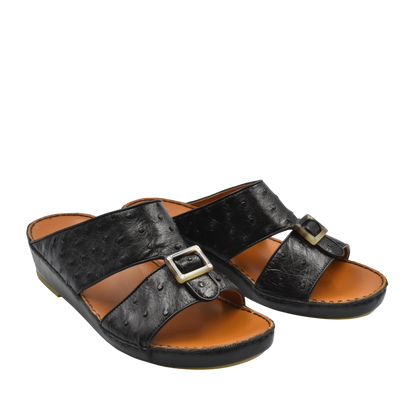 Black ostrich leather sandals with buckle detail and cushioned tan footbed