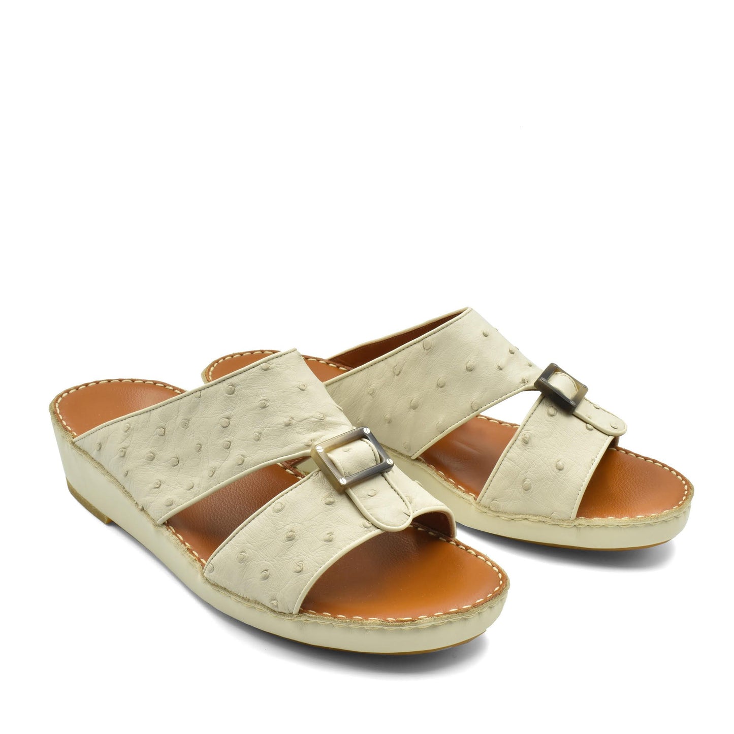 Beige ostrich leather sandals with buckle detail and cushioned tan footbed for comfort