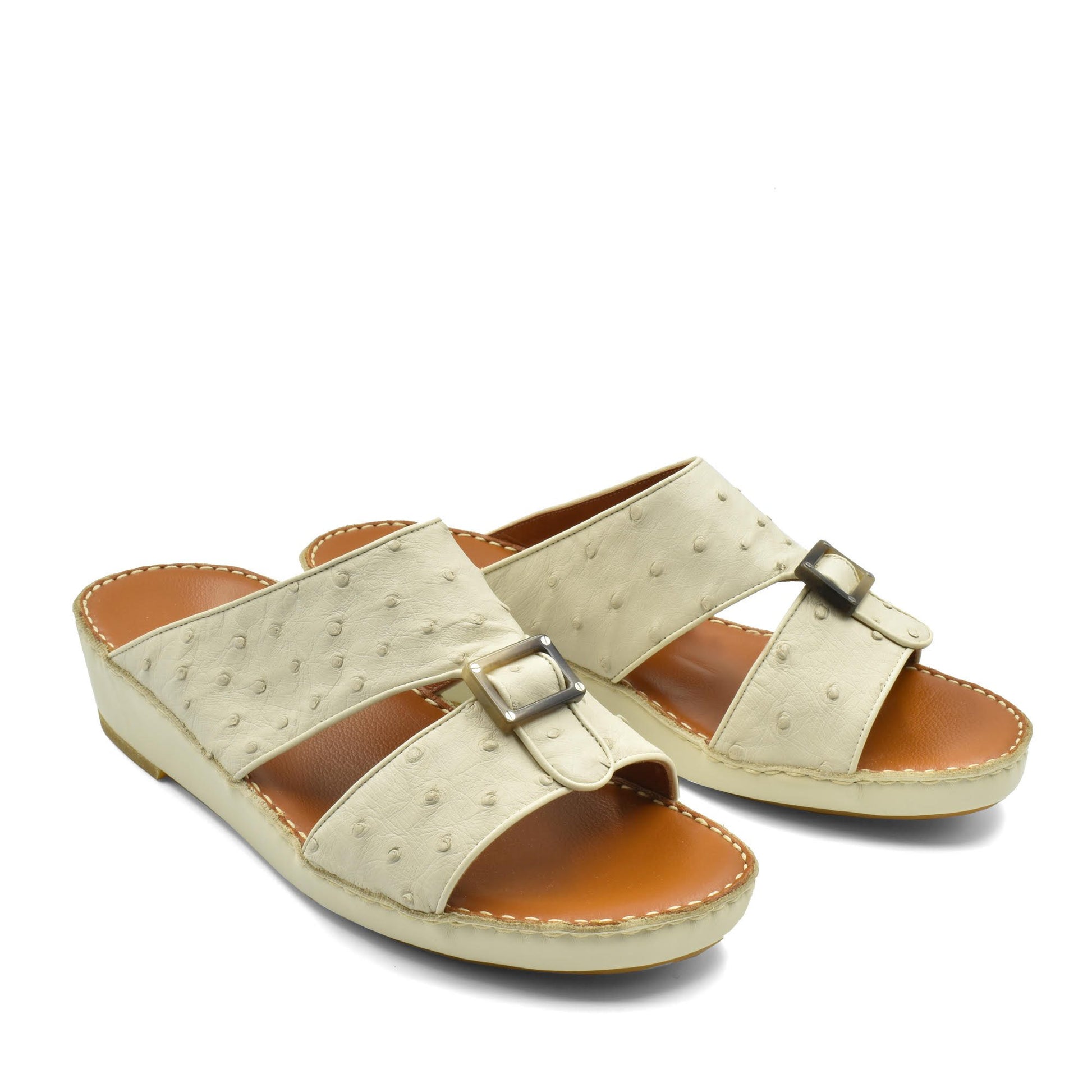 Beige ostrich leather sandals with buckle detail and cushioned tan footbed for comfort