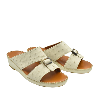 Beige ostrich leather sandals with buckle detail and cushioned tan footbed for comfort
