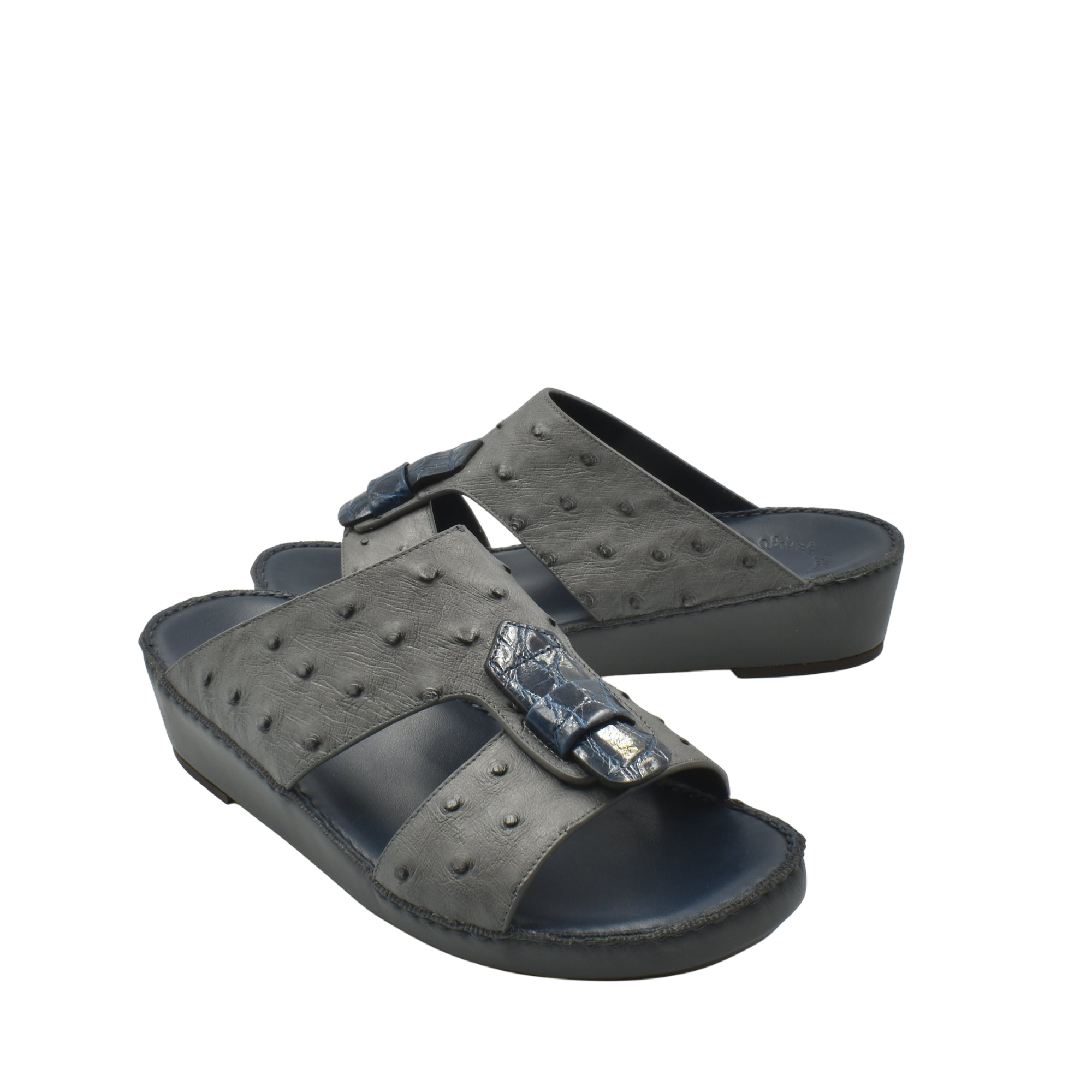 Black ostrich leather sandals with raised texture and decorative buckle on thick sole